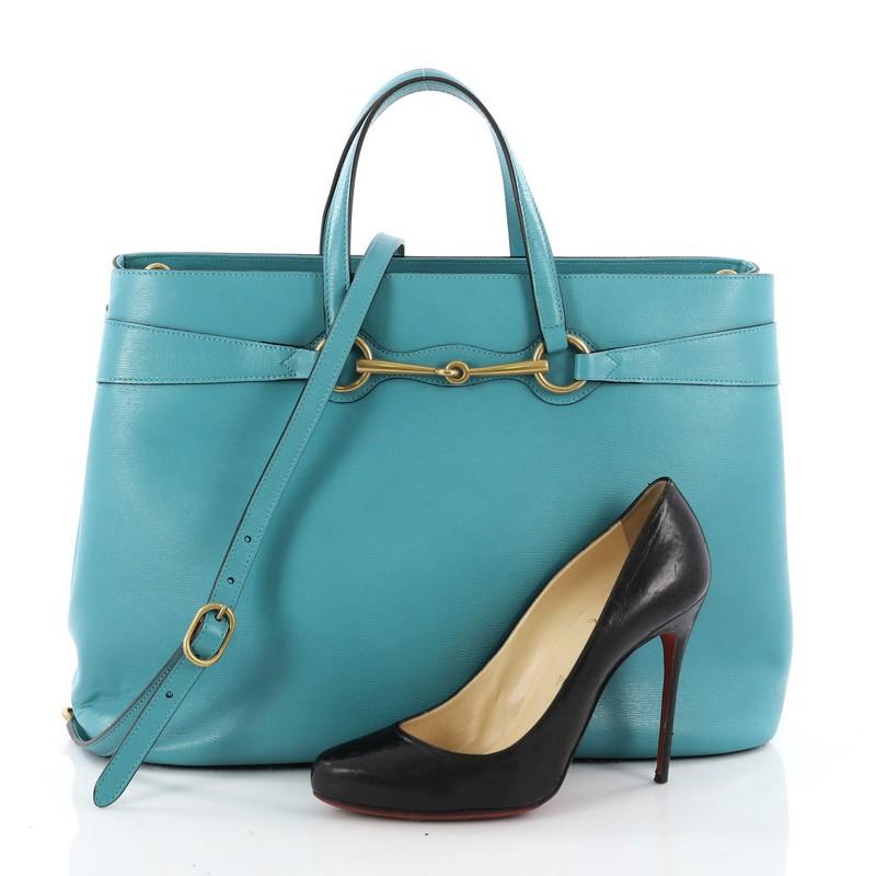 This authentic Gucci Bright Bit Convertible Tote Leather Large is simple yet luxurious in design. Crafted in light blue leather, this minimalist yet chic bag features dual leather handles, signature horsebit design, side snap buttons, protective
