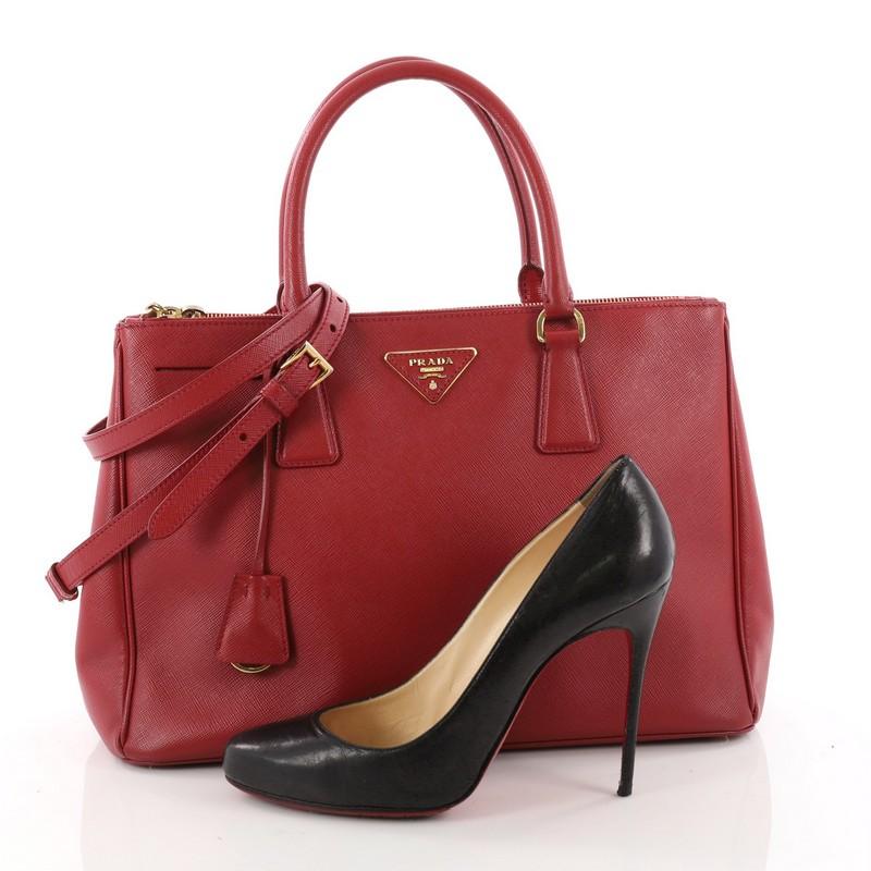 This authentic Prada Double Zip Lux Tote Saffiano Leather Medium is the perfect bag to complete any outfit. Crafted from red saffiano leather, this boxy tote features side snap buttons, raised Prada logo plate, dual-rolled leather handles and