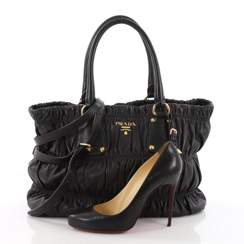 This authentic Prada Gaufre Convertible Tote Nappa Leather Medium is a beautifully and intricately crafted bag perfect for everyday use. Constructed in black gaufre nappa leather, this bag features dual-rolled handles with buckle detailing,