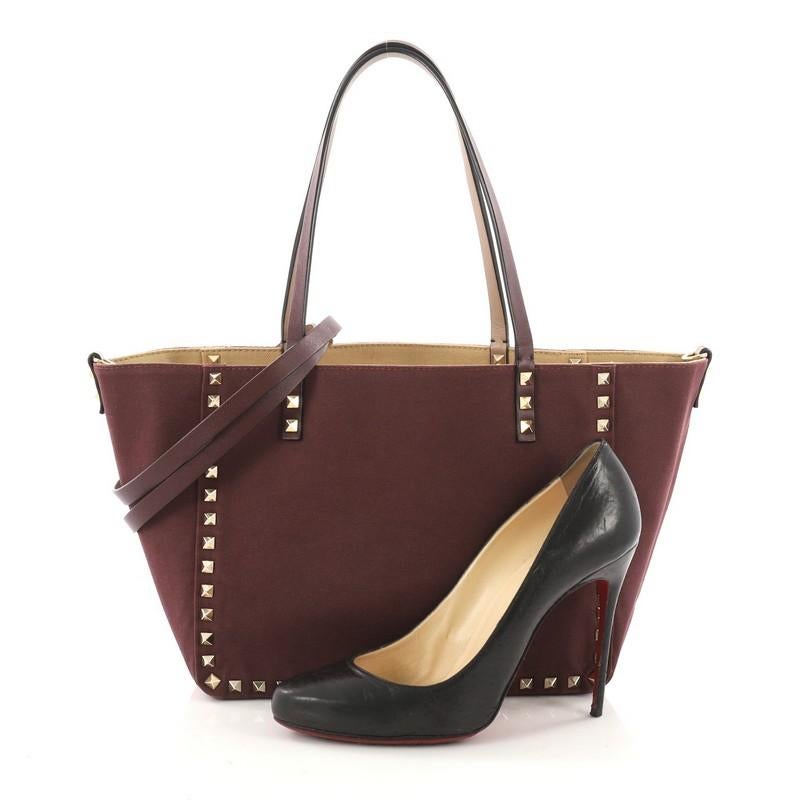 This authentic Valentino Rockstud Reversible Convertible Tote Canvas Small is perfect daily bag for any on-the-go fashionista. Crafted from maroon and beige canvas, this tote features the brand's iconic pyramid rockstud detailing, dual tall flat