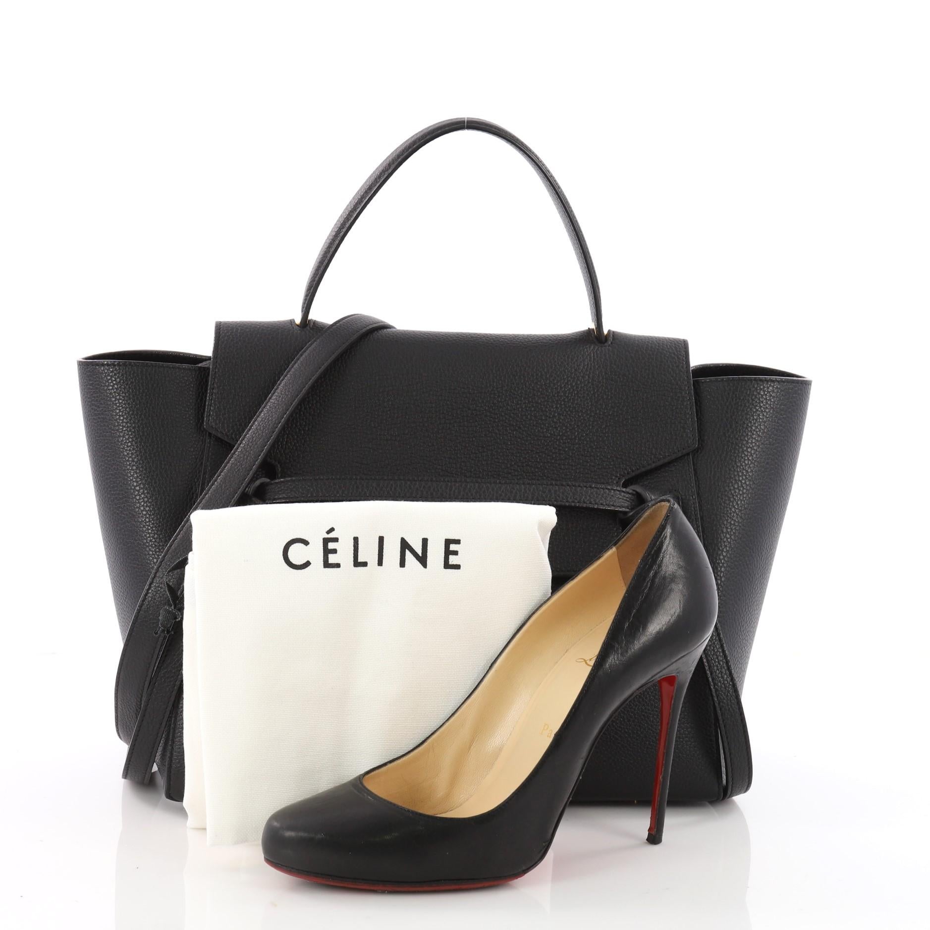 This authentic Celine Belt Bag Grainy Leather Mini is sure to make a statement. Crafted from black grainy leather, this bold and beautiful bag features expanded wings, looped single top handle, top flap slide closure, knotted ties, zipper pocket at