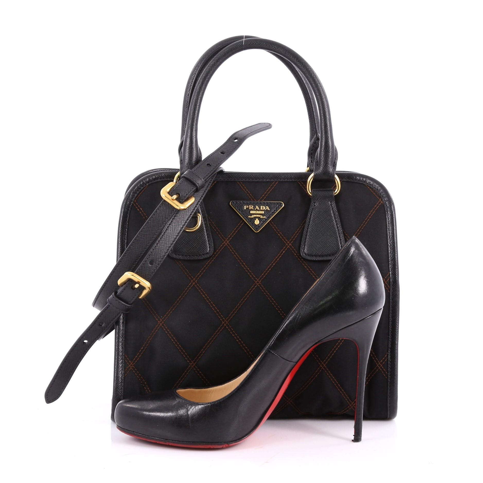 This authentic Prada Impunturato Convertible Tote Quilted Tessuto Small is the perfect bag to complete any outfit. Crafted from black impunturato quilted tessuto, this boxy tote features Prada logo, dual-rolled leather handles and gold-tone hardware