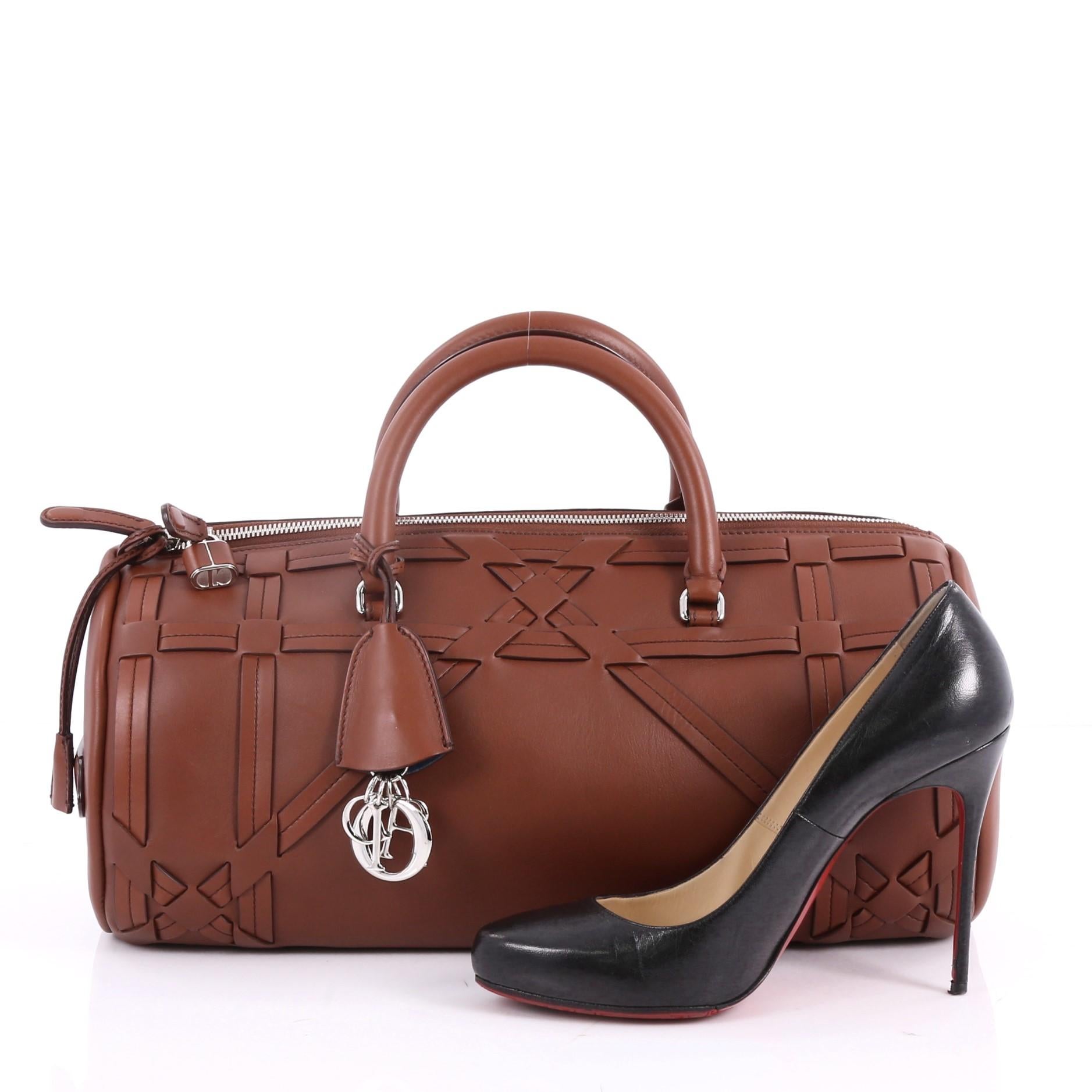 This authentic Christian Dior Connect Duffle Bag Giant Cannage Woven Leather is a gorgeous runway piece. Crafted in brown cannage woven leather, this stylish tote features dual-rolled leather handles, dual slit pockets at side, and silver-tone