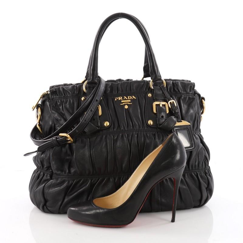 This authentic Prada Gaufre Convertible Tote Nappa Leather Medium is a beautifully and intricately crafted bag perfect for everyday use. Constructed in black gaufre nappa leather, this bag features dual-rolled handles with buckle detailing,