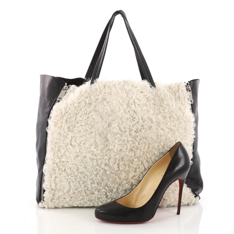 This authentic Celine Horizontal Gusset Cabas Tote Shearling and Leather Large is the perfect oversized travel companion to fit all your essentials and more. Crafted with off-white Shearling and black leather, this open-top tote features dual-slim