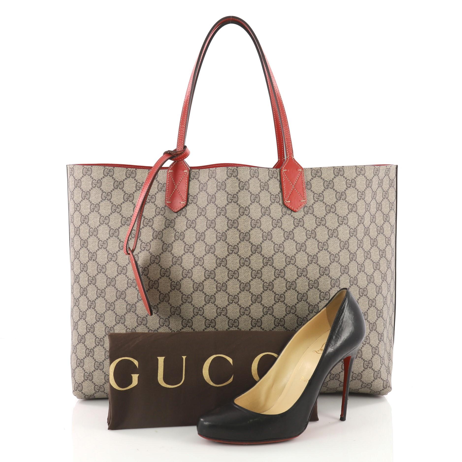 This authentic Gucci Reversible Tote GG Print Leather Medium is perfect for everyday casual looks. Crafted in brown GG print and red leather on its reverse side, this simple shopper-style tote features tall slim handles and subtle Gucci logo at the