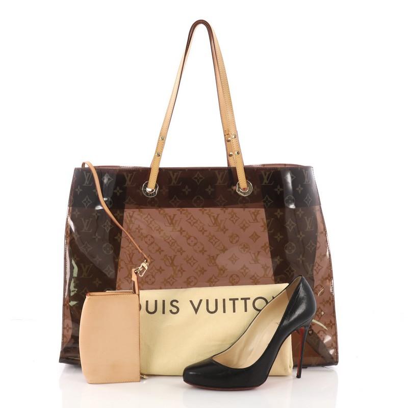 This authentic Louis Vuitton Ambre Sac Cabas Monogram Vinyl GM showcases a playful design perfect for casual days. Constructed from brown monogram ambre vinyl and cowhide leather trims, this oversized stylish tote features vachetta leather straps,