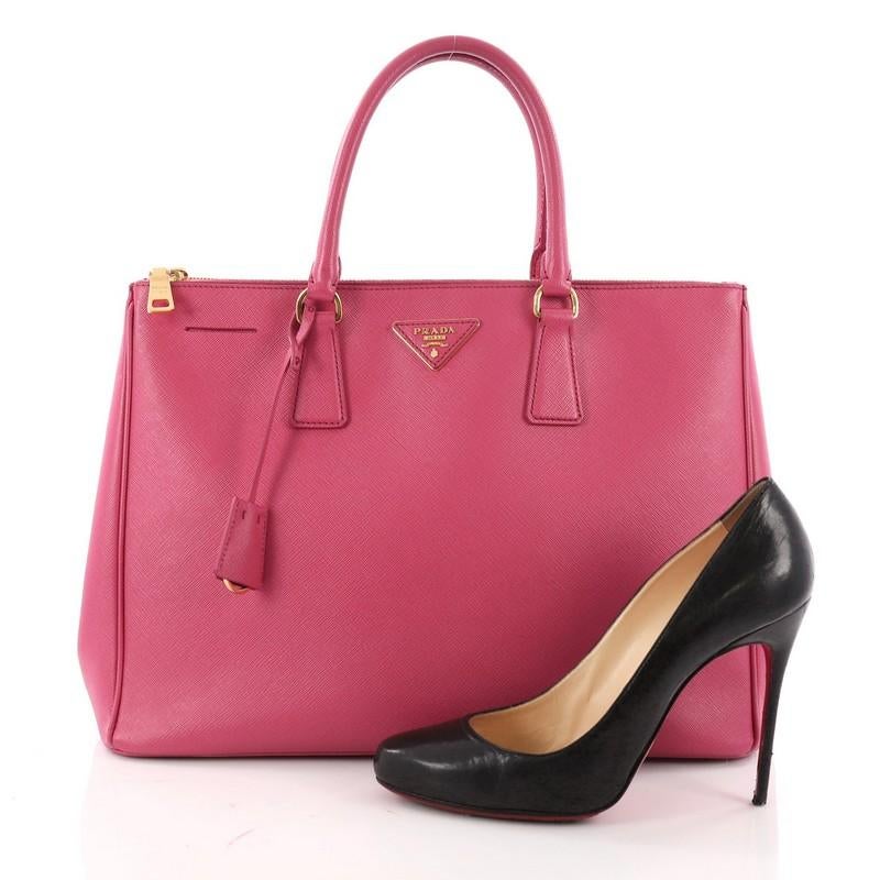 This authentic Prada Double Zip Lux Tote Saffiano Leather Medium is the perfect bag to complete any outfit. Crafted from pink saffiano leather, this boxy tote features side snap buttons, raised Prada logo plate, dual-rolled leather handles, and