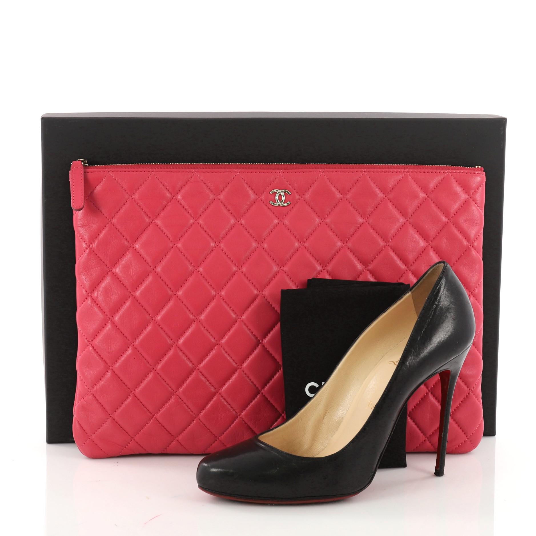 This authentic Chanel O Case Clutch Quilted Lambskin Large adds a touch of elegance to your everyday outfits. Crafted from pink quilted lambskin, this chic clutch features a tiny CC logo on the front and gold-tone hardware accents. Its zip closure