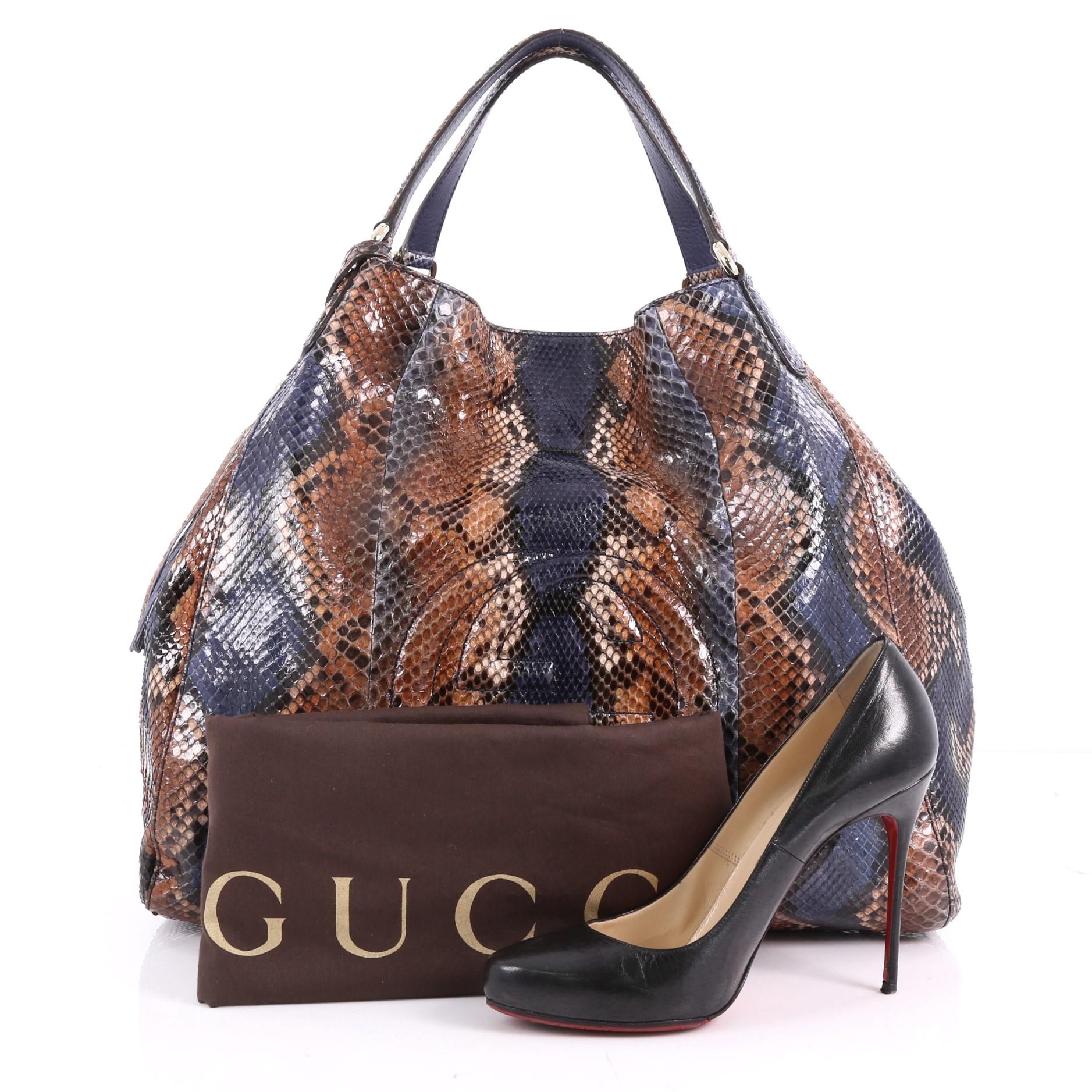 This authentic Gucci Soho Shoulder Bag Python Large is simple yet luxuriously stylish in design. Crafted from genuine brown and blue python skin, this hobo features dual flat handles, fringe tassels, protective base studs, signature interlocking