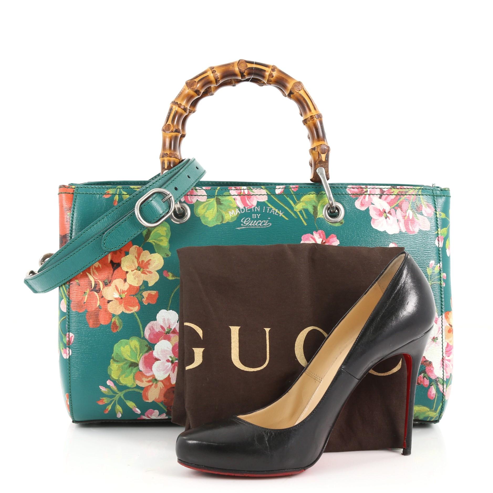 This authentic Gucci Bamboo Shopper Tote Blooms Print Leather Medium is a classic must-have. Crafted from green blooms print leather, this simple yet stylish tote features Gucci's signature sturdy bamboo handles, protective base studs, stamped logo