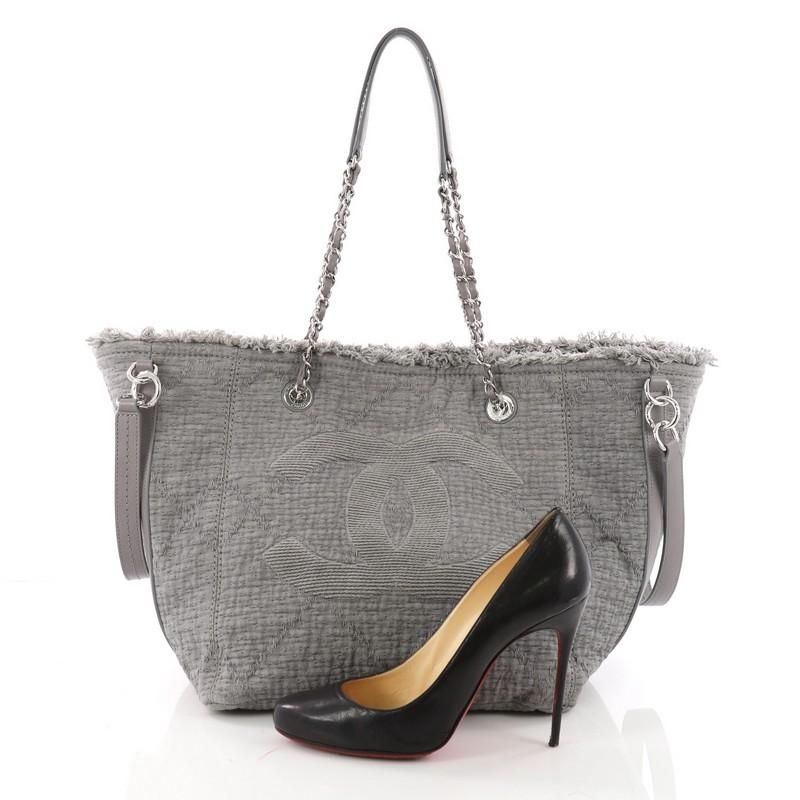 This authentic Chanel CC Open Tote Fringe Quilted Canvas Medium is perfect for everyday use with a classic yet luxurious style. Crafted in grey fringe quilted canvas, this versatile timeless tote features dual woven-in leather straps with shoulder