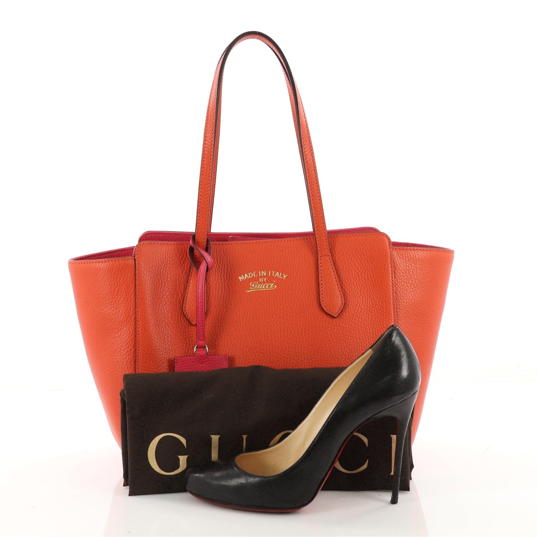 This authentic Gucci Swing Tote Leather Small is modern and sophisticated in design. Crafted in orange leather, this elegant tote features tall dual-slim handles, Gucci stamped logo at the front, expanded wing silhouette, and gold-tone hardware