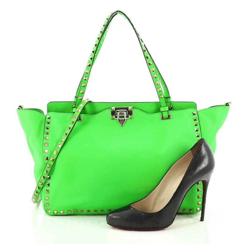 This authentic Valentino Rockstud Tote Soft Leather Medium mixes edgy style with luxurious detailing. Crafted from neon green soft leather, this stylish tote features dual tall flat handles, gold-tone pyramid stud trim details, signature clasp lock,