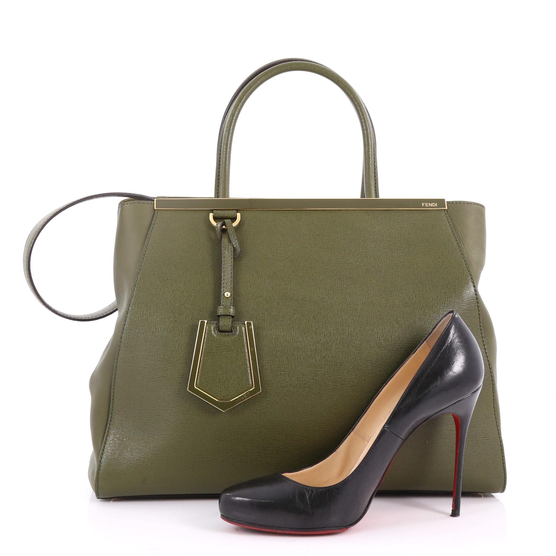 This authentic Fendi 2Jours Handbag Leather Medium is impeccably stylish with a simple silhouette and structured design. Finely crafted in green leather with soft calfskin sides, this popular tote features a shining top bar, protective base studs,