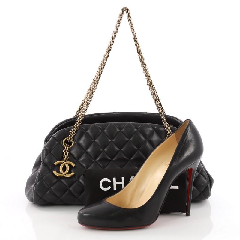 This authentic Chanel Just Mademoiselle Handbag Quilted Lambskin Medium showcases a sleek style that complements any look. Crafted from black lambskin leather in Chanel's iconic diamond stitch pattern, this bag features Chanel Reissue chain straps
