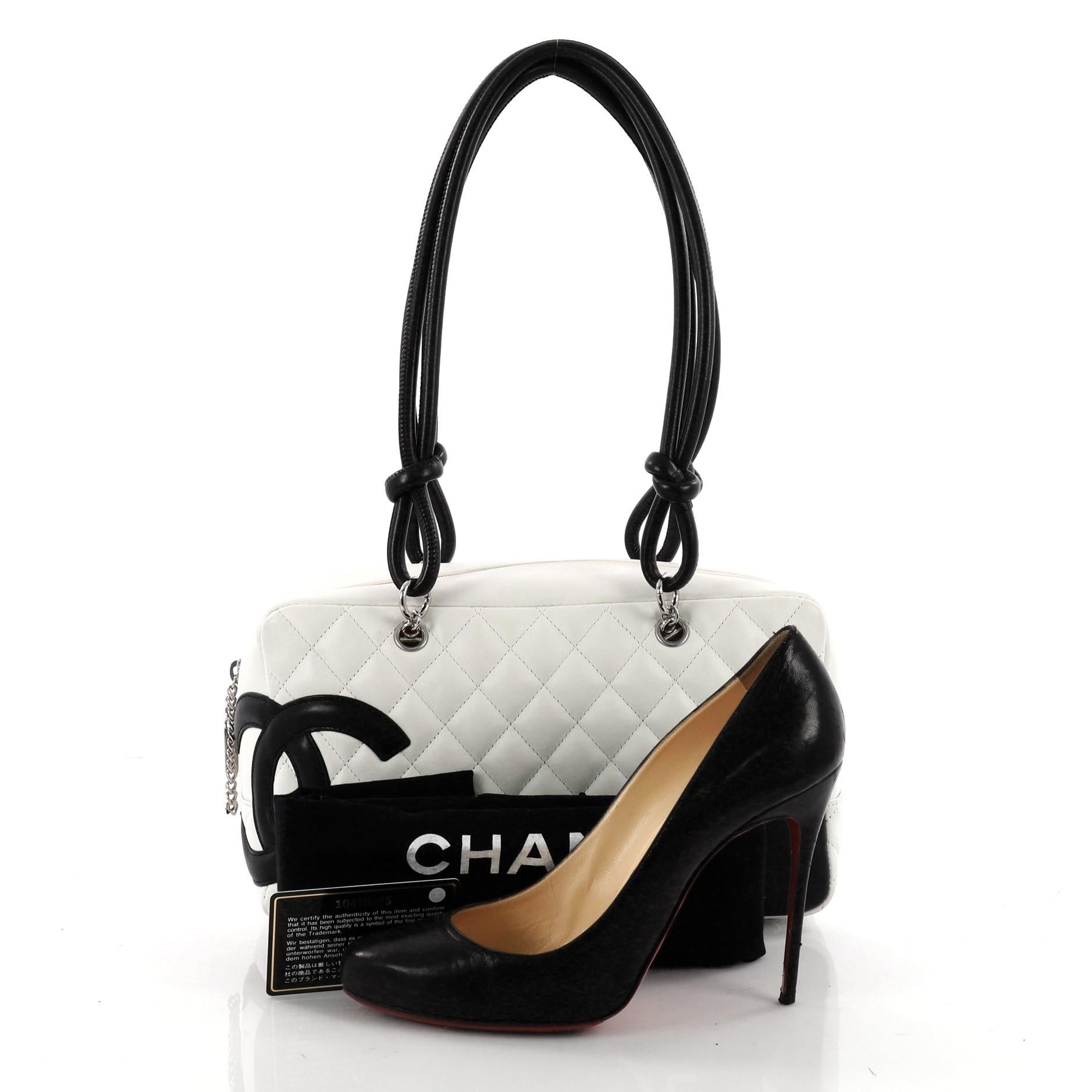 This authentic Chanel Cambon Bowler Bag Quilted Leather Medium is a chic and stylish bag from the brand's Cambon collection. Crafted from white diamond quilted leather, this handbag features a large black interlocking CC side logo, rolled leather