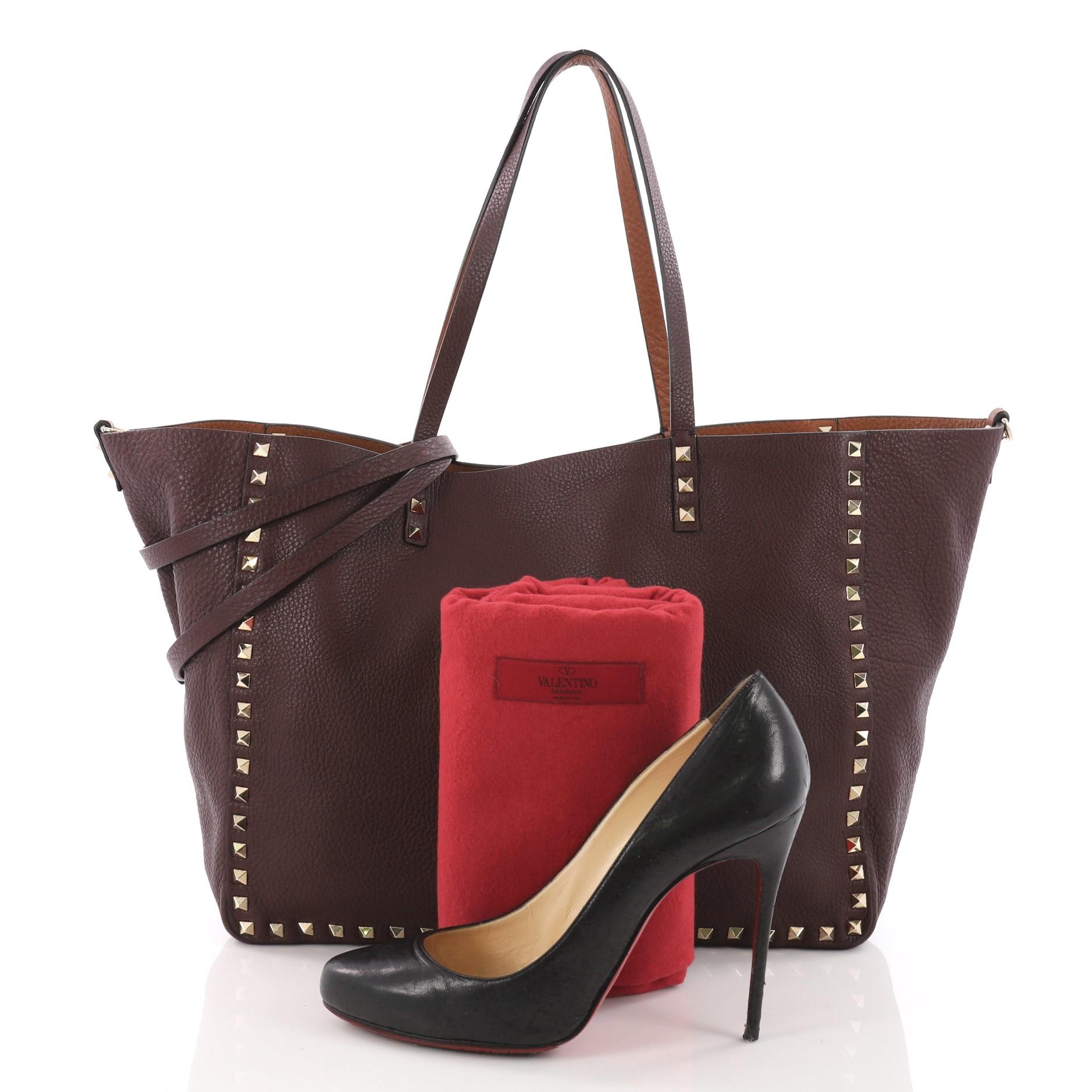 This authentic Valentino Rockstud Reversible Convertible Tote Leather Medium is a perfect daily bag for any on-the-go fashionista. Crafted from burgundy and brown reversible leather, this tote features the brand's iconic pyramid rockstud detailing,