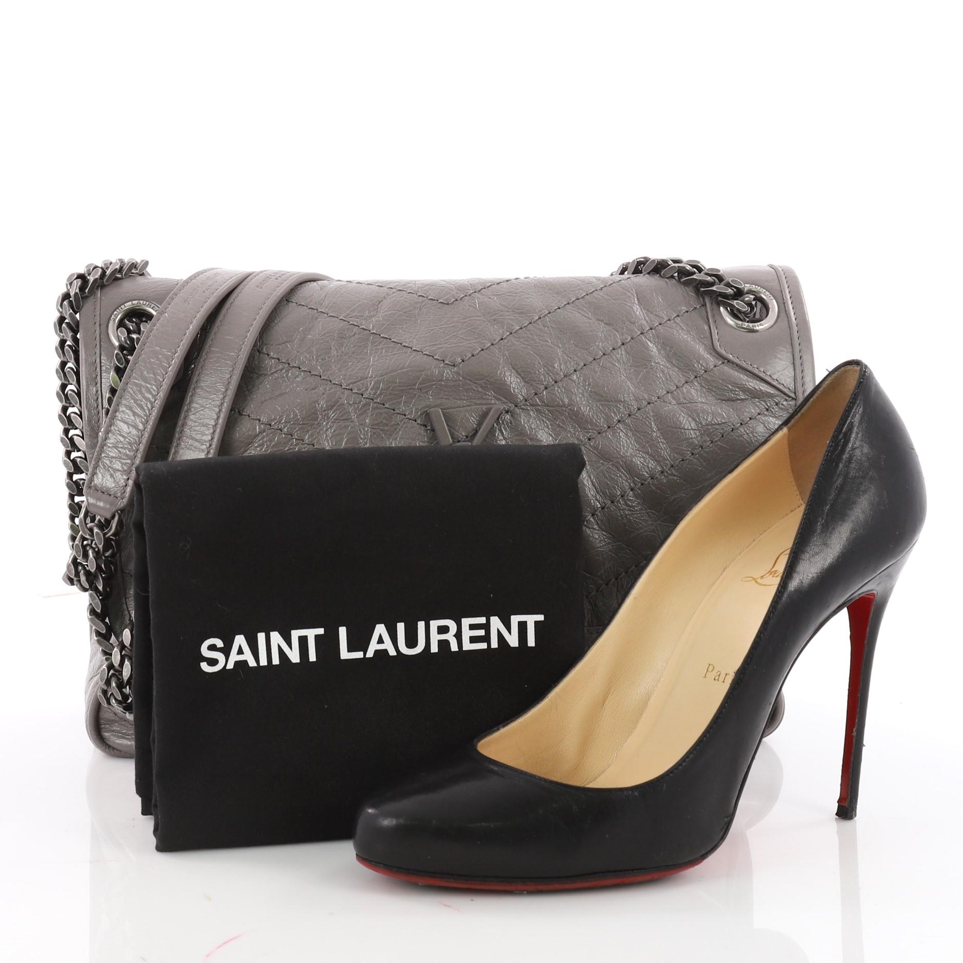 This authentic Saint Laurent Niki Chain Flap Bag Matelasse Chevron Leather Medium is an ideal bag for your day or evening looks. Crafted in grey matelasse  chevron leather, this elegant bag features chain link shoulder strap with a matching leather