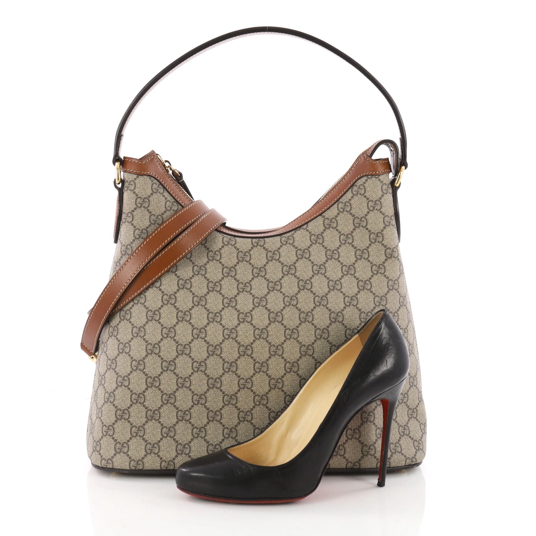 This authentic Gucci Linea A Hobo GG Coated Canvas is an elegant bag perfect for everyday casual looks. Crafted in brown GG supreme coated canvas, this structured bag features curved top handle, brown leather trims, exterior back slip pocket.