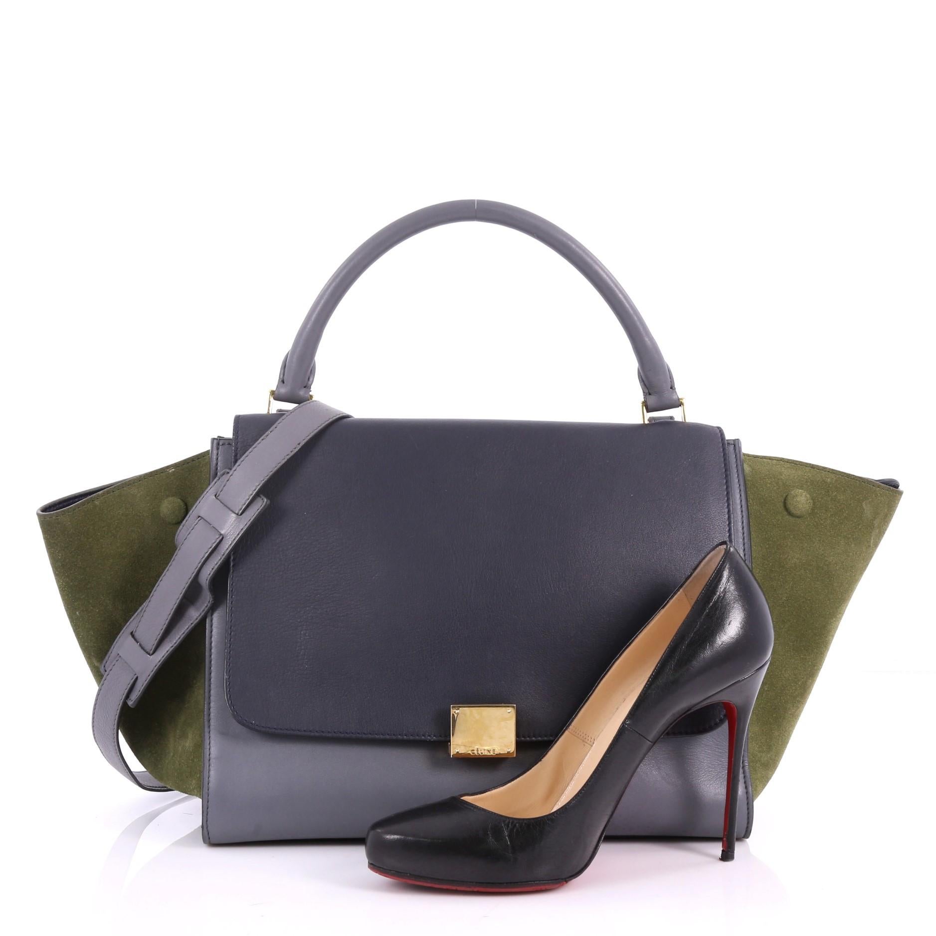 This authentic Celine Tricolor Trapeze Handbag Leather Medium is a modern minimalist design with a playful twist in an array of subdued colors. Crafted from grey leather and green side suede wings, this popular bag features gold-tone hardware