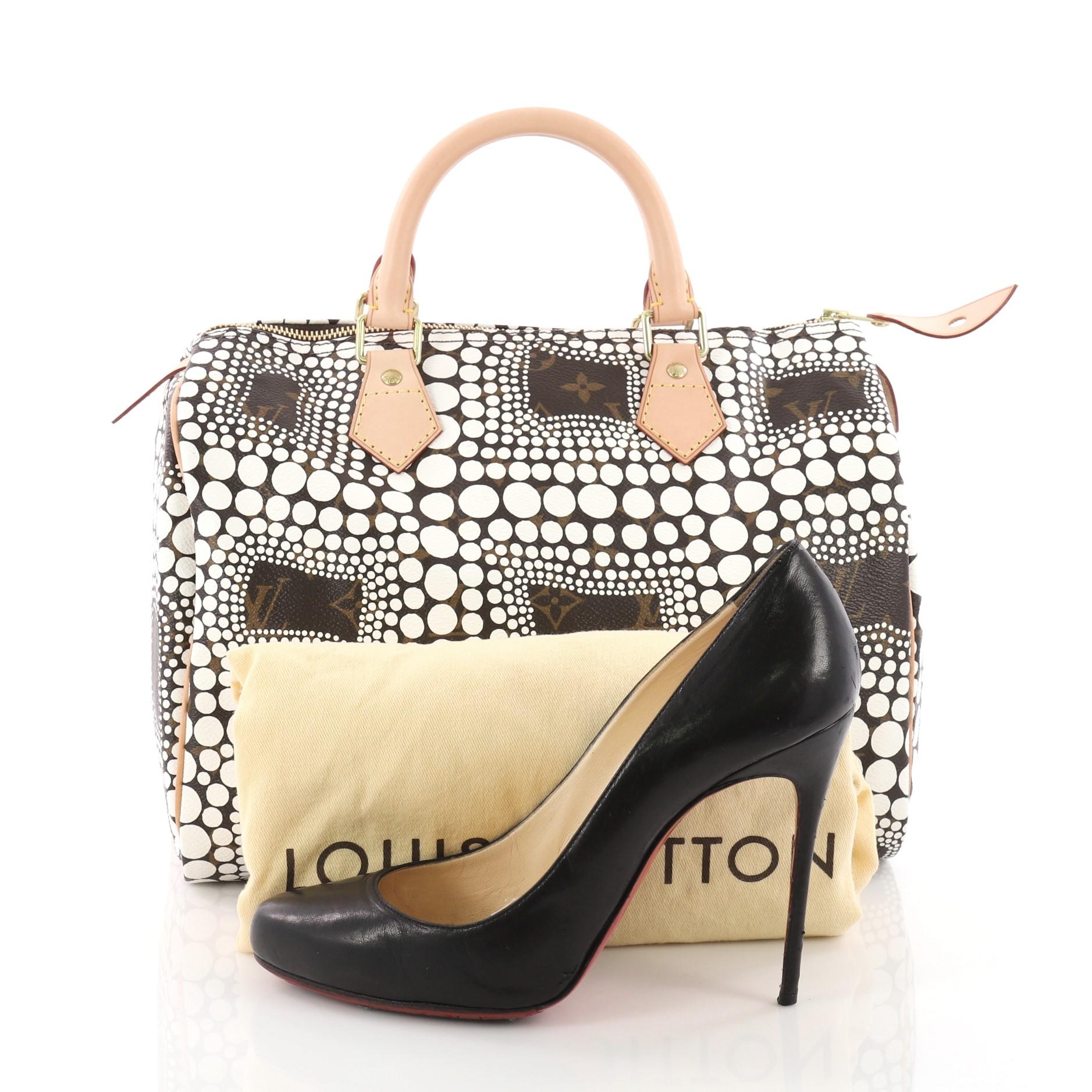 This authentic Louis Vuitton Speedy Handbag Limited Edition Monogram Canvas Kusama Town 30 showcases a design created by renowned Japanese artist Yayoi Kusama. Crafted from Louis Vuitton's brown monogram canvas, this limited edition Speedy features