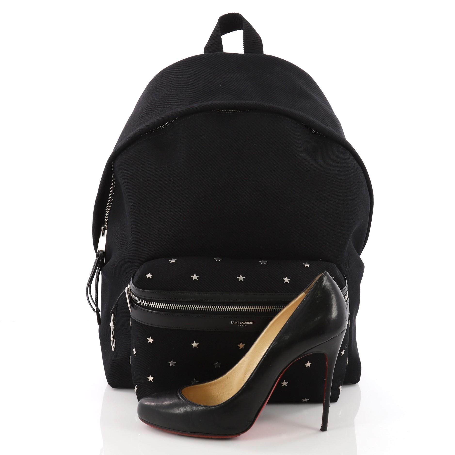 This authentic Saint Laurent City Backpack Canvas with Applique Medium is an eye-catching and luxurious style made for on-the-go fashionistas. Crafted from black canvas with star applique, this unique bag features, adjustable padded strap, exterior