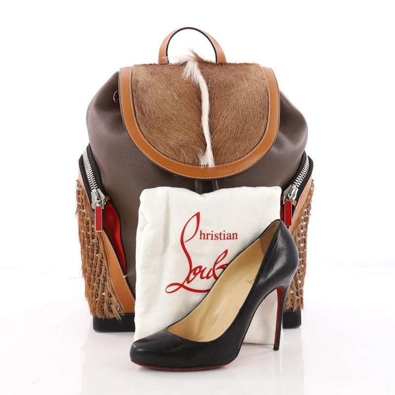 This authentic Christian Louboutin Explorafunk Backpack Spiked Leather and Fur is a chic bag showcasing the French designer's edgy style. Crafted in brown spiked leather and fur, this bag features flat leather top handle, adjustable leather shoulder