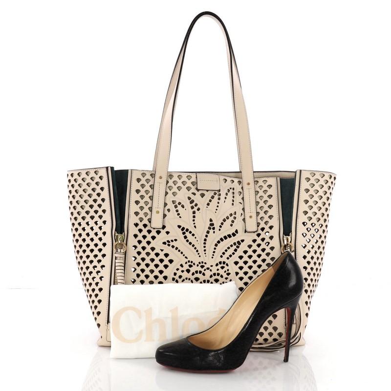 This authentic Chloe Milo Shopping Tote Laser Cut Leather Medium is an excellent tote, ideal for everyday use. Crafted in beige laser cut leather with a pineapple design on the front, this chic tote features, dual-flat leather handles, front
