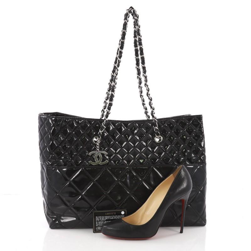 This authentic Chanel In The Business Tote Quilted Patent Vinyl Large is a marvelous tote perfect for your everyday looks. Crafted from black patent vinyl, this timeless bag features dual woven-in leather chain straps, diamond quilted design, CC
