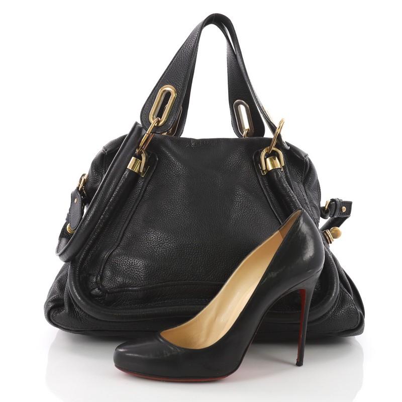 This authentic Chloe Paraty Top Handle Bag Leather Medium mixes everyday style and functionality perfect for the modern woman. Crafted from black leather, this versatile bag features dual flat handles, piped trim details, side twist locks, and