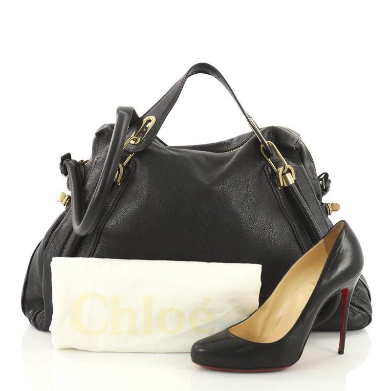 This authentic Chloe Paraty Top Handle Bag Leather Large mixes everyday style and functionality perfect for the modern woman. Crafted from sleek black leather, this versatile bag features piped trim details, dual flat handles, side twist locks and