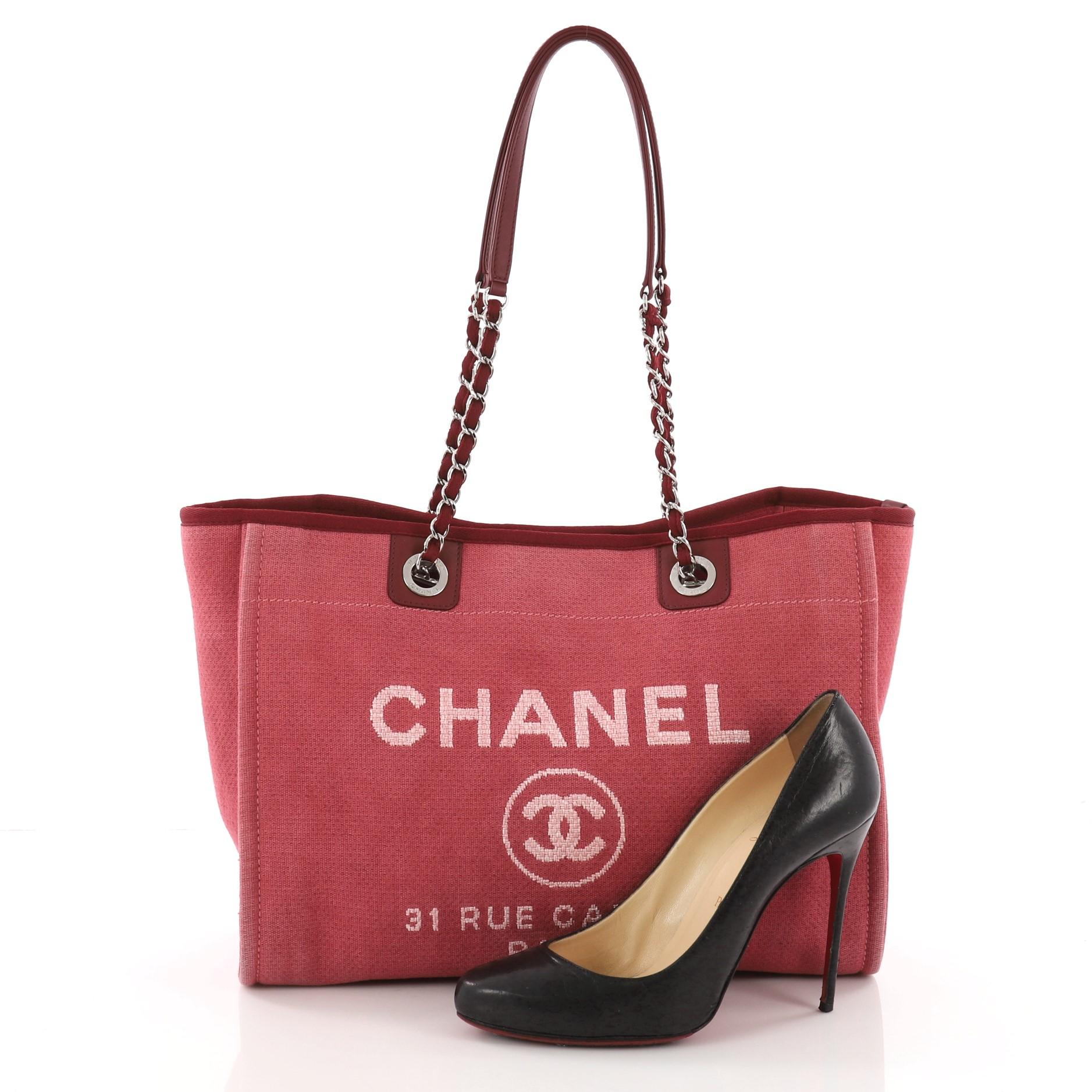 This authentic Chanel Deauville Chain Tote Canvas Small embodies a casual-chic style made for any fashionista. Crafted in dark red canvas, this stylish tote features dual woven-in canvas chain straps, printed CC logo with Chanel's famous Parisian