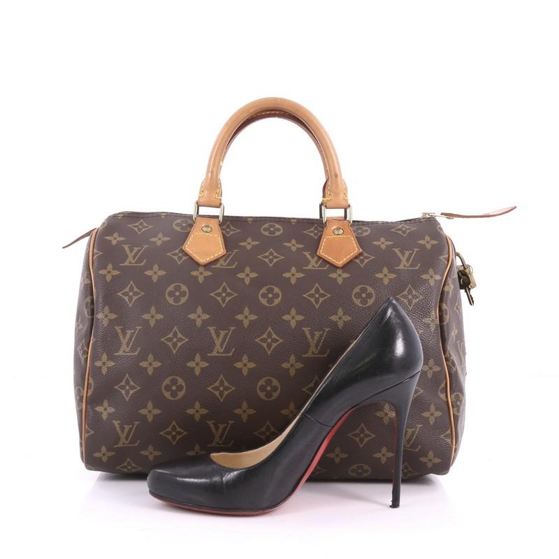 This authentic Louis Vuitton Speedy Handbag Monogram Canvas 30 is spacious and light, making it ideal to use everyday. Constructed in Louis Vuitton's classic brown monogram coated canvas, this iconic Speedy features dual-rolled leather handles,