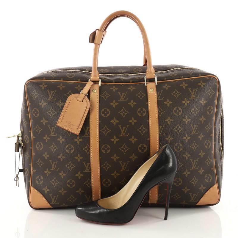 This authentic Louis Vuitton Sirius Handbag Monogram Canvas 45 showcases the brand's traditional and timeless luxury travel design. Crafted in iconic brown monogram coated canvas, this handbag features natural cowhide vachetta corners and trims,