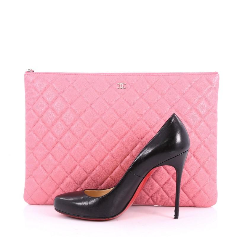 This authentic Chanel O Case Clutch Quilted Caviar Large adds a touch of elegance to your everyday outfits. Crafted from pink quilted caviar leather, this chic clutch features a tiny CC logo on the front and silver-tone hardware accents. Its zip