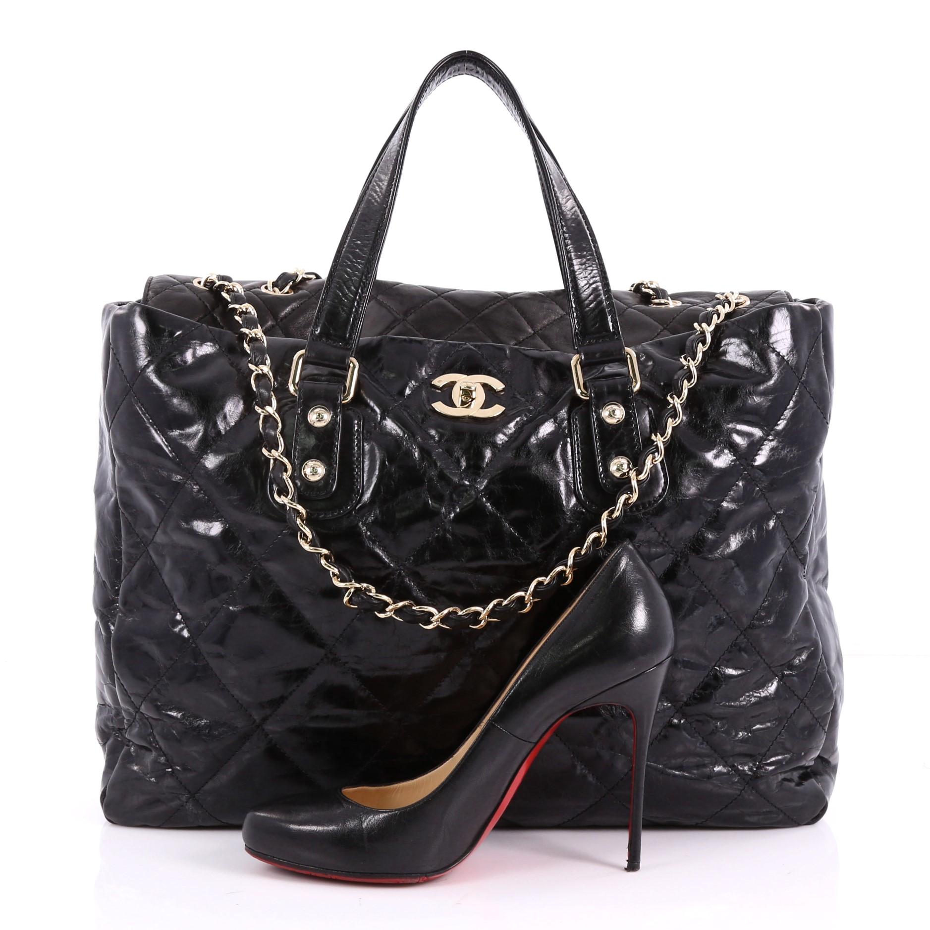 This authentic Chanel Portobello Tote Quilted Glazed Calfskin Large is a luxurious bag perfect for everyday use. Crafted from black glazed calfskin, this bag features dual-flat leather handles, CC logo at front, protective base studs and gold-tone