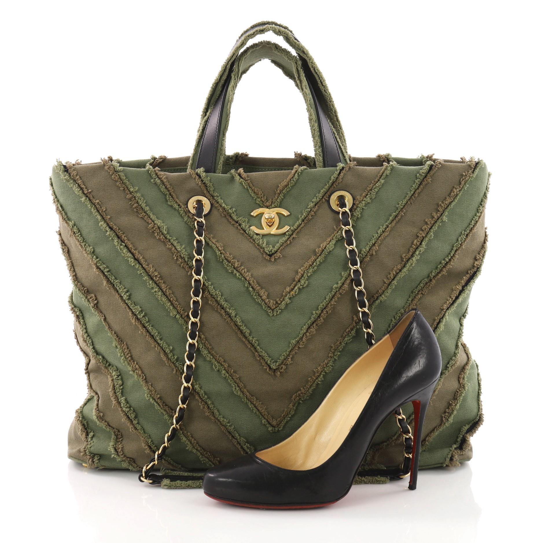 This authentic Chanel Shopping Tote Chevron Canvas Patchwork Large is from the brand's Cruise 2017 Cuba Collection. Crafted from green chevron patchwork canvas, this bag features dual top handles, woven-in leather chain straps with shoulder pads,