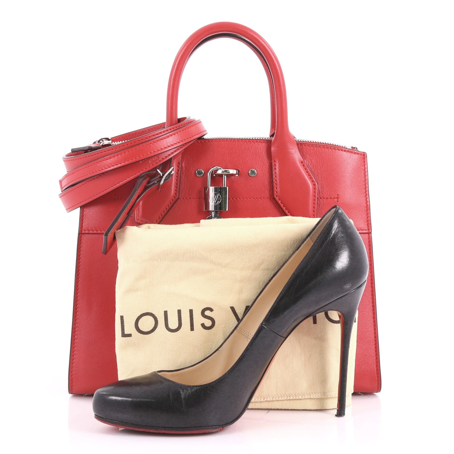 This Louis Vuitton City Steamer Handbag Leather PM, crafted in red calfskin leather, features dual rolled leather handles, front central lock, and silver-tone hardware. It opens to a red leather interior with rear zip compartment and slip pockets.