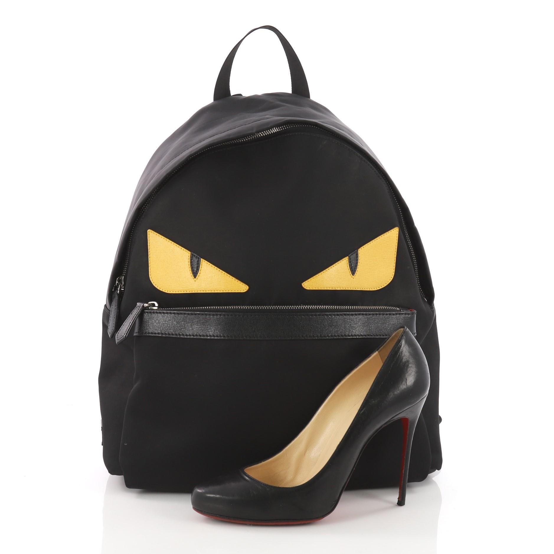 This authentic Fendi Monster Backpack Nylon Large balances a luxurious, playful style made for on-the-go fashionistas. Crafted from black nylon, this backpack features monster eye applique design, a flat top handle, padded adjustable shoulder