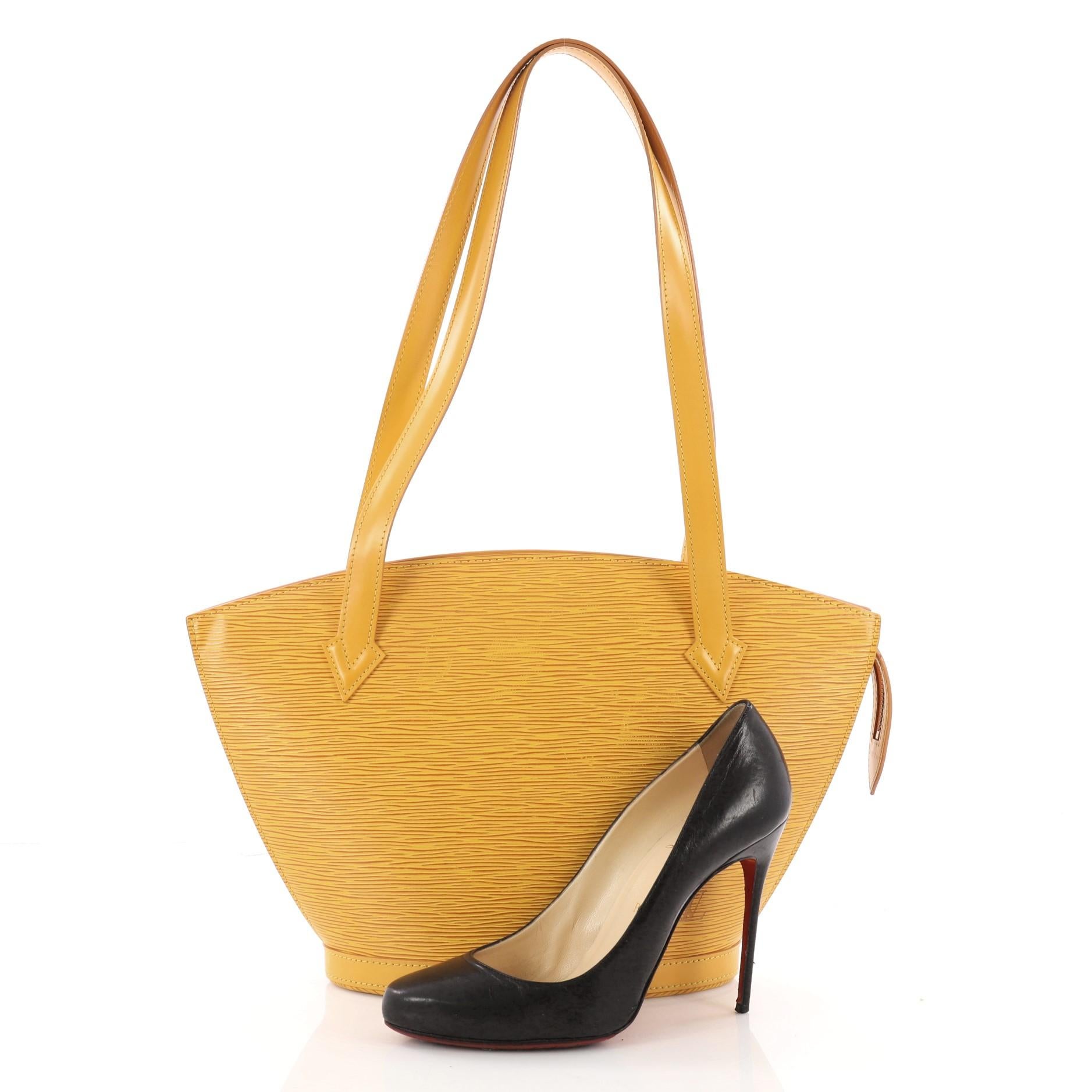 This authentic Louis Vuitton Saint Jacques Handbag Epi Leather PM is refined and elegant. Crafted from yellow epi leather, this fan-shaped slim shoulder bag features long straps, subtle LV logo at the front and a gold-tone hardware accents. Its zip