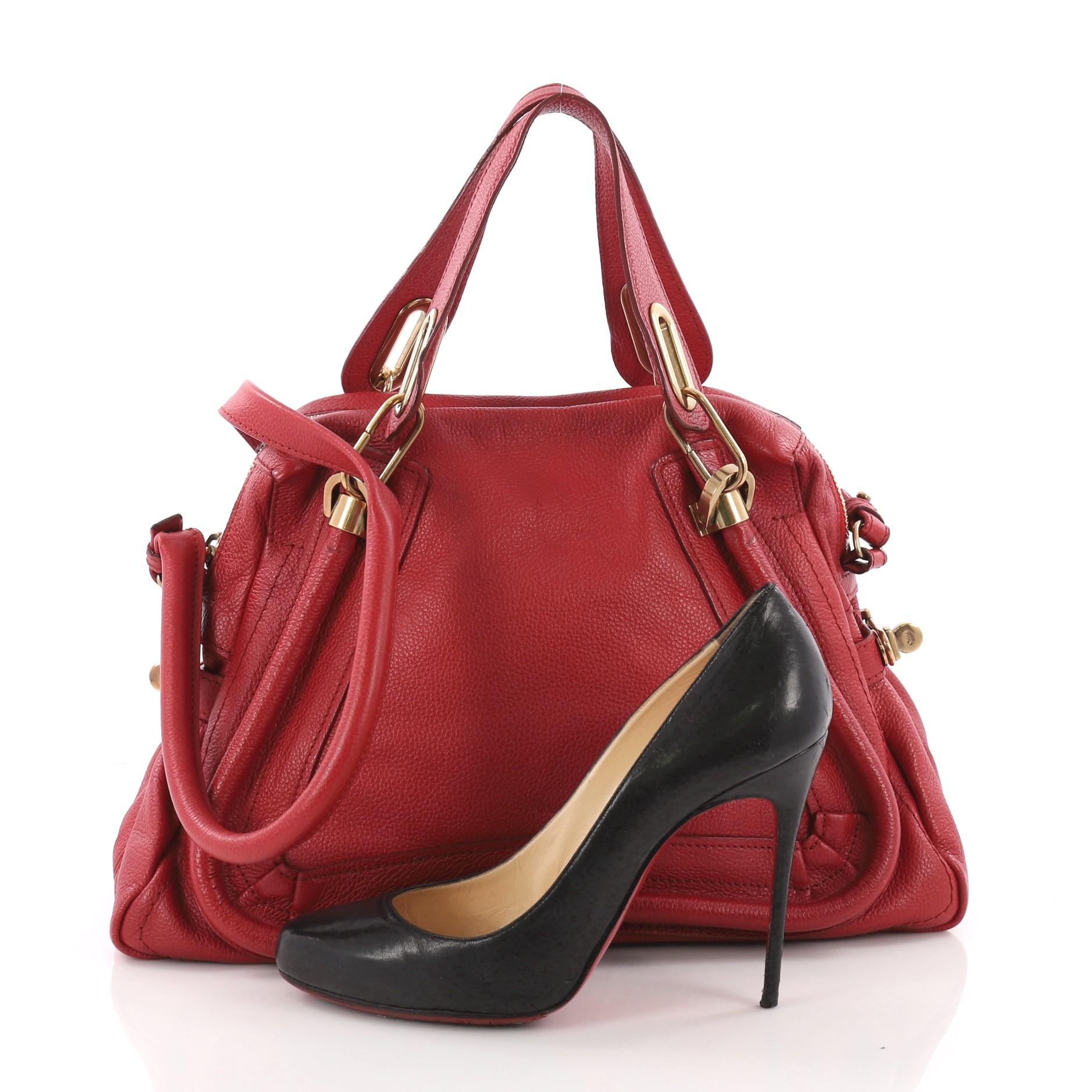 This authentic Chloe Paraty Top Handle Bag Leather Medium mixes style with functionality. Crafted from red leather, this versatile bag features dual flat handles, piped trim details, side twist locks, and gold-tone hardware accents. Its top zip