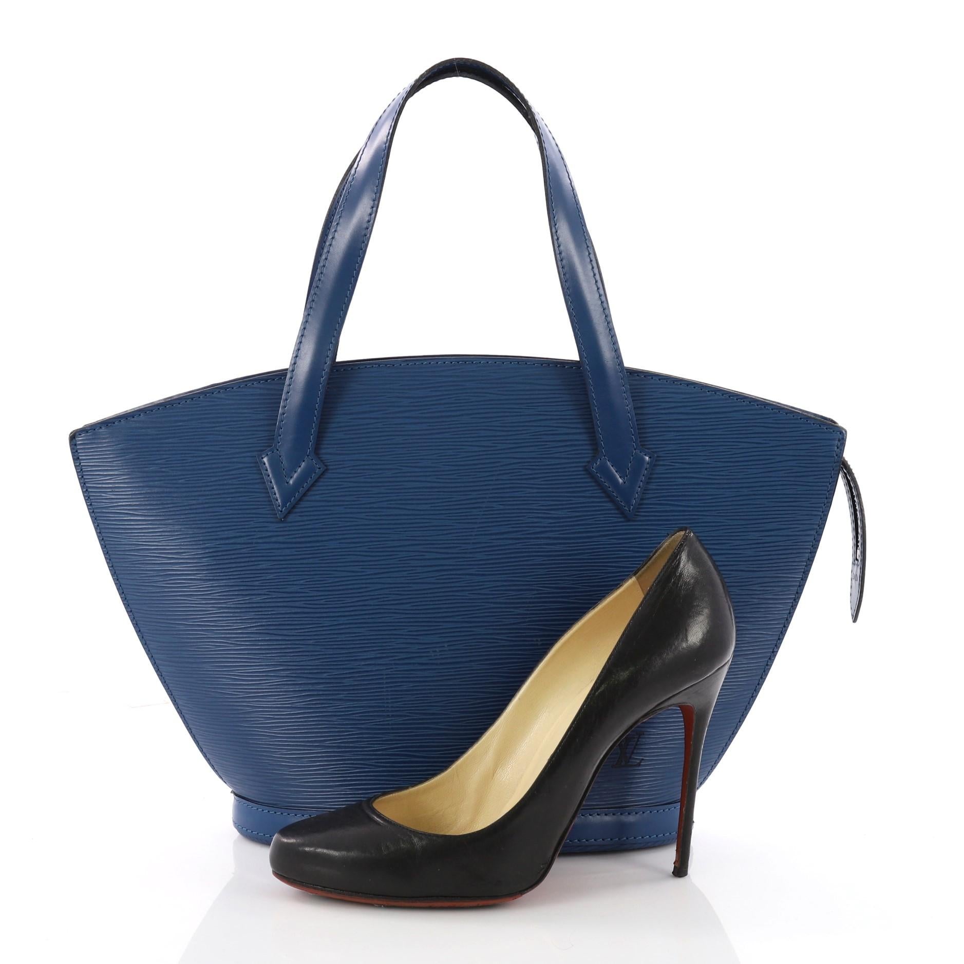 This authentic Louis Vuitton Saint Jacques Handbag Epi Leather PM is refined and elegant. Crafted from Louis Vuitton's signature blue epi leather, this fan-shaped bag features long straps, subtle LV logo at the front and gold-tone zip closure. Its