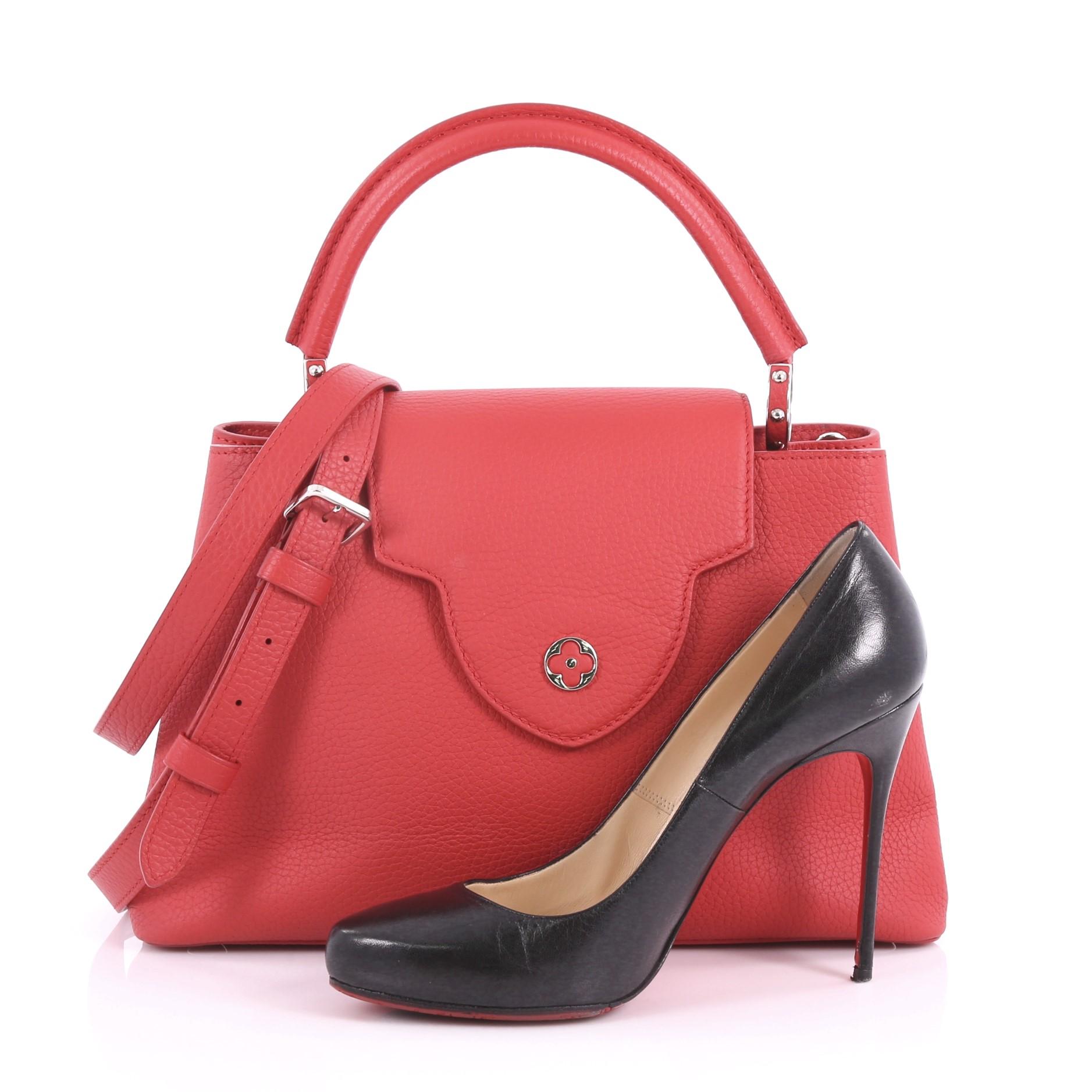 This authentic Louis Vuitton Capucines Handbag Leather PM is a sophisticated and ladylike luxurious bag inspired by its Parisian heritage. Crafted from red taurillon leather, this chic bag features a single loop leather handle secured by jewel-like
