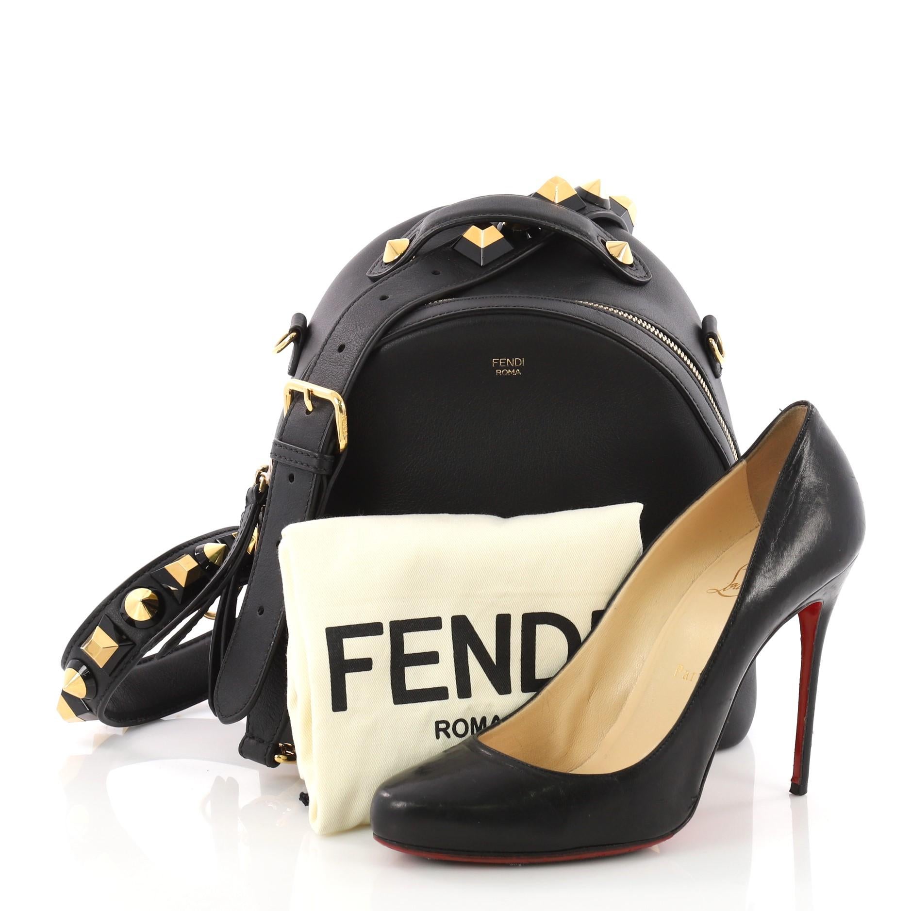 This authentic Fendi By The Way Backpack Crossbody Studded Leather Mini balances a luxurious, playful style made for on-the-go fashionistas. Crafted in black leather, this bag features oversize gold studs, leather top handle, detachable studded