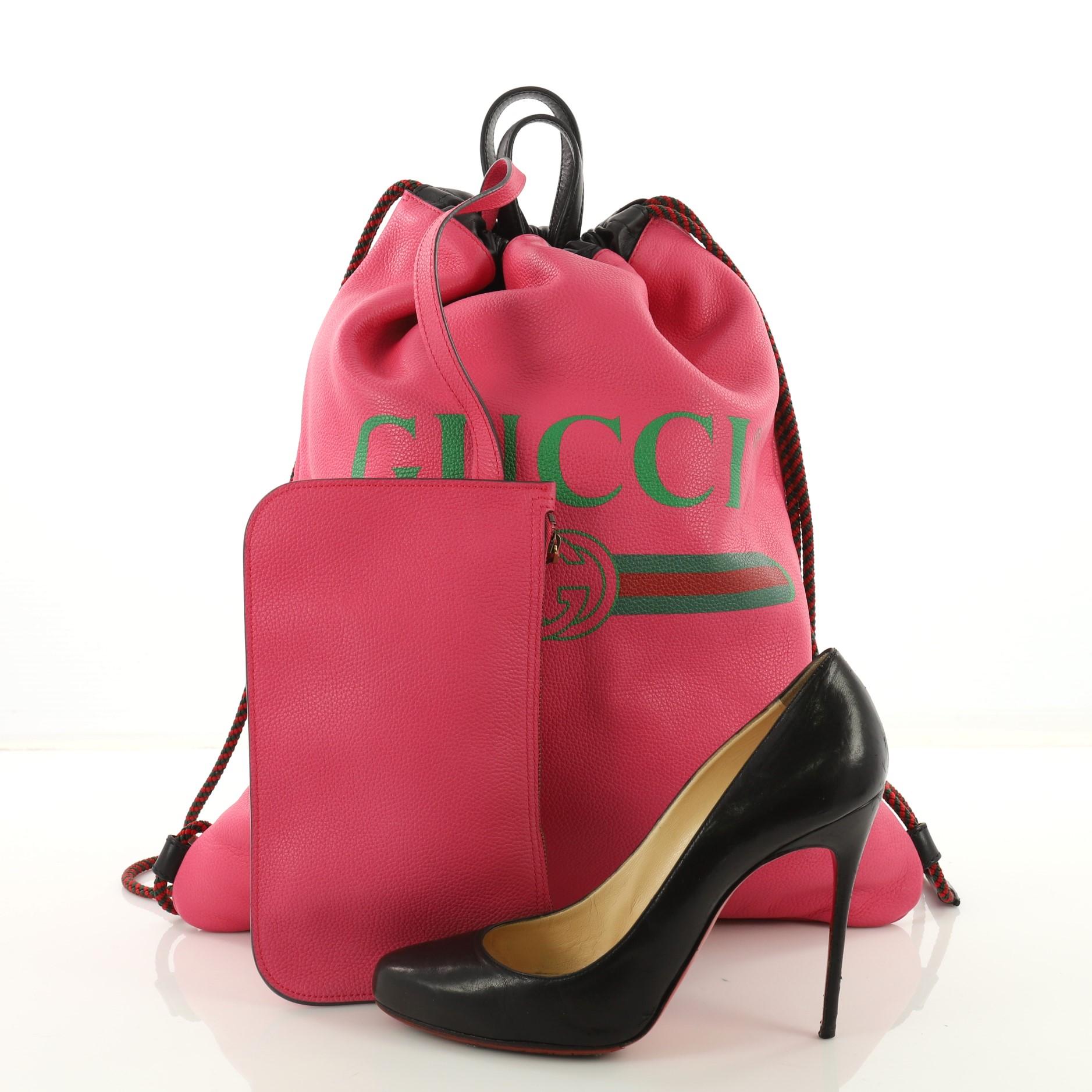 This Gucci Logo Drawstring Backpack Printed Leather Large, crafted in pink printed leather, features dual leather handles, ope straps that double function as a drawstring and aged gold-tone hardware. Its drawstring closure opens to a pink leather