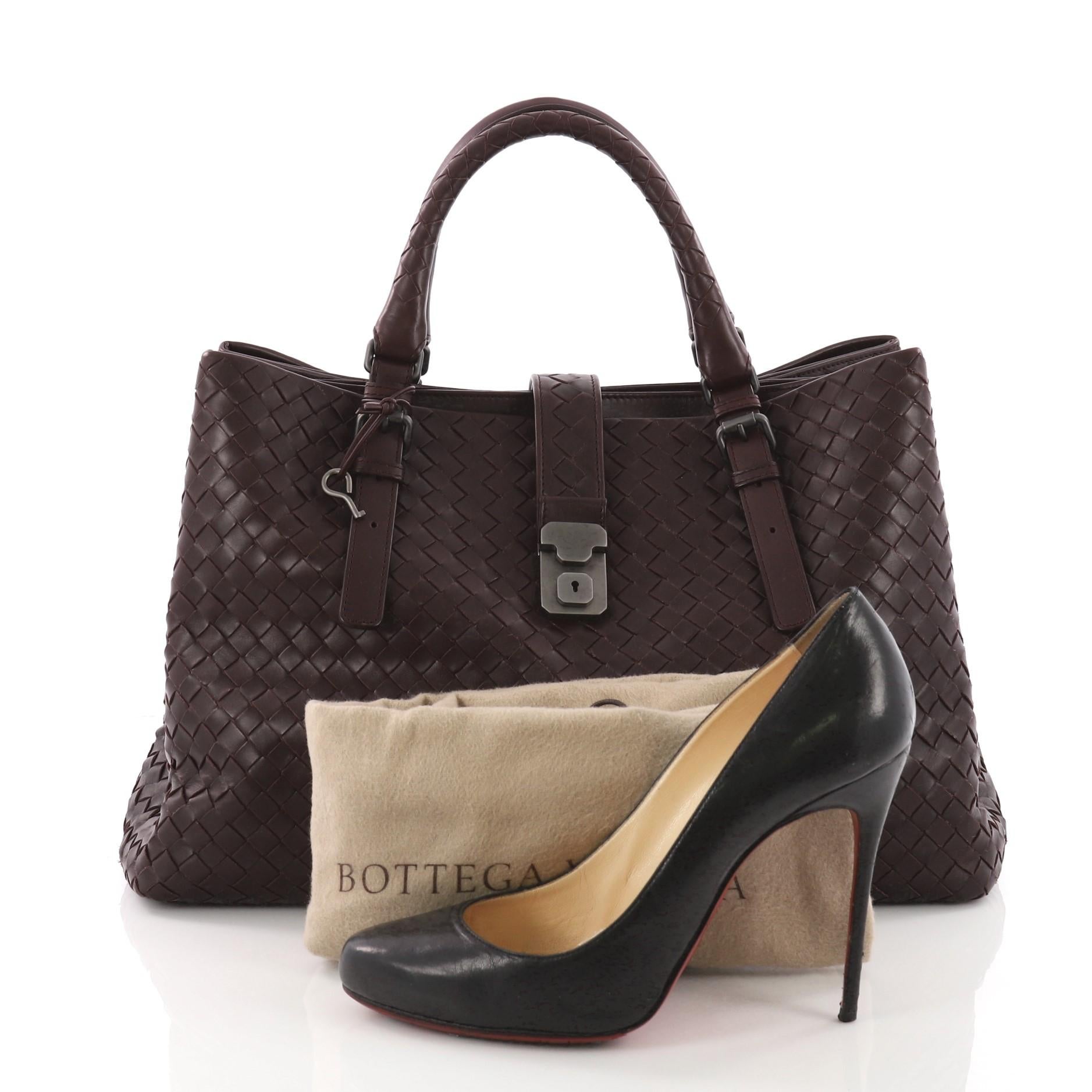 This authentic Bottega Veneta Roma Handbag Intrecciato Nappa Medium is a finely crafted tote that exudes an understated elegance. Crafted from dark purple nappa leather woven in Bottega Veneta's signature intrecciato method, it features dual woven