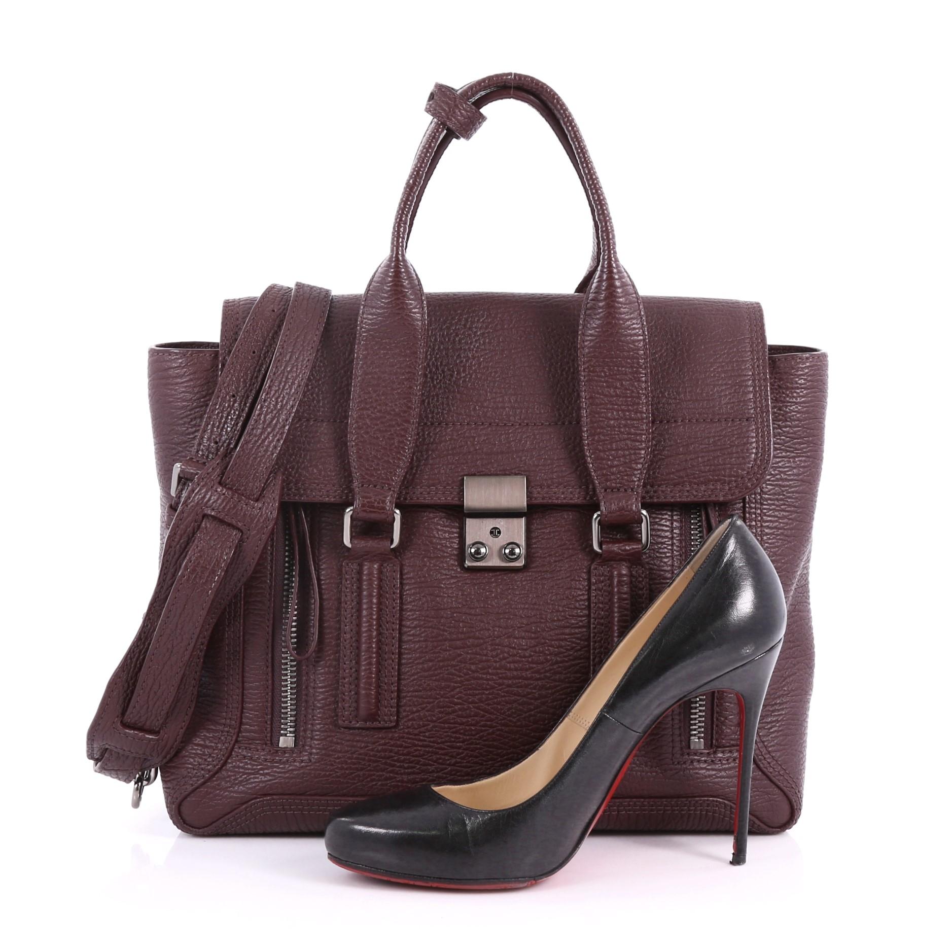 This authentic 3.1 Phillip Lim Pashli Satchel Leather Medium is a practical bag with a stylish edge made for on-the-go moments. Crafted from maroon leather, this chic satchel features dual top handles, expandable zip sides, top flap push-lock