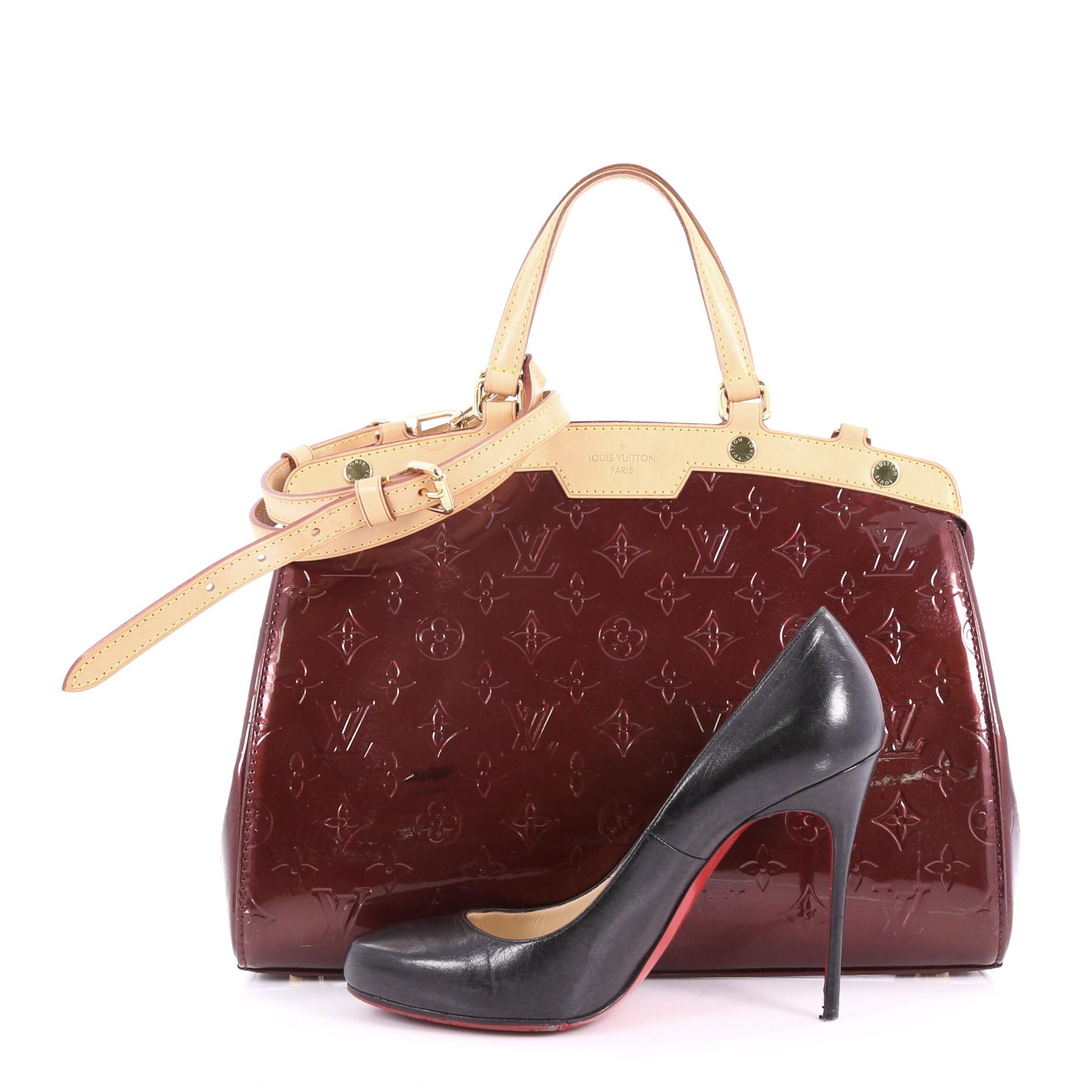 This Louis Vuitton Brea Handbag Monogram Vernis MM, crafted in dark red monogram vernis leather, features dual flat handles, cowhide leather trims, and gold-tone hardware accents. Its zip closure opens to a dark red fabric interior with zip and slip