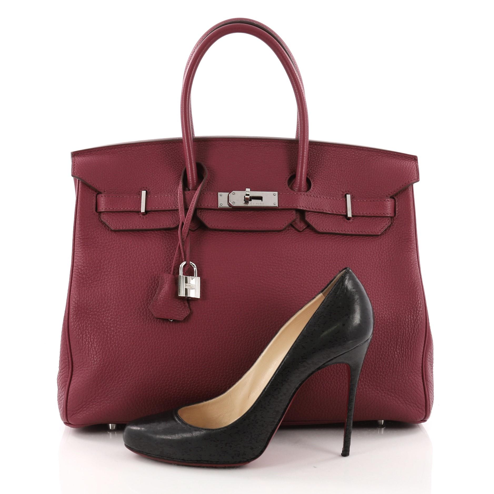 This Hermes Birkin Handbag Rubis Togo with Palladium Hardware 355, crafted from Rubis togo leather, features dual rolled handles, front flap and palladium-tone hardware. Its turn-lock closure opens to a pink leather interior with slip pocket. Date